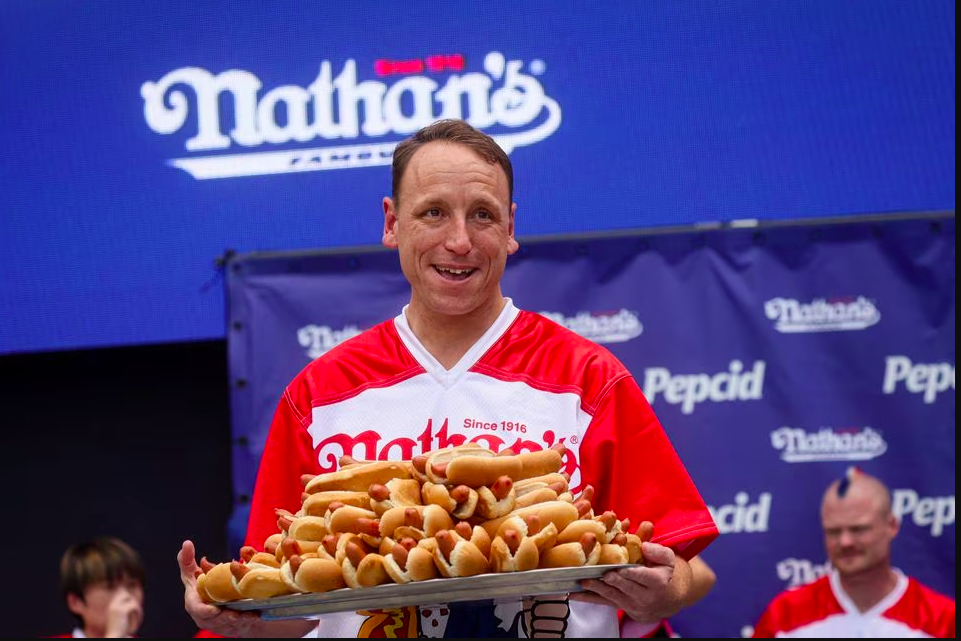 Cine este bărbatul care mănâncă peste 60 de hotdogi în 10 minute